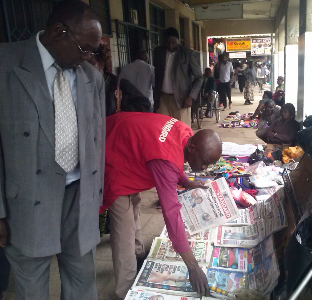 Kennedy Ouko rearranges a variety of Kenyan dailies at his stall along Tom Mboya Street in Nairobi.